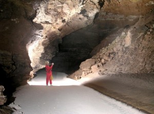 A Caver standing on Fort Stanton Cave's Snowy River.