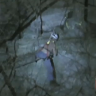 Trapped man being lowered by rescuers.