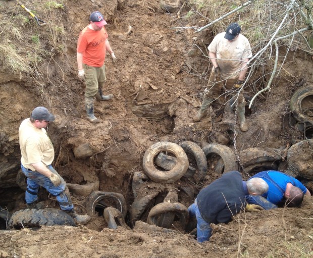 Cavers chaining together tires for removal.