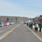 Cars of visitors line up along highway 13.