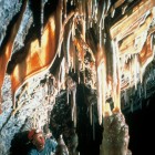 A caver examines formations in King's Row, a part of the Cave Tour at Glenwood Caverns & Historic Fairy Caves in Glenwood Springs, Colorado