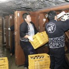 Workers store sake bottles on shelves inside Ryusendo cave.